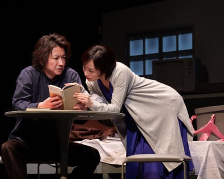 A man and a woman hunched over a book