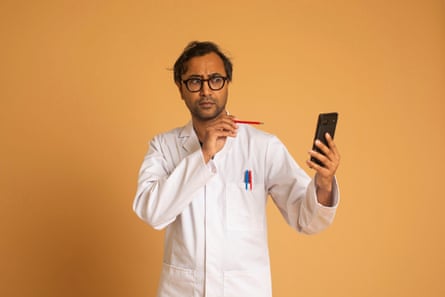 Rhik wearing a lab coat holding a pen and a phone, against an orange background