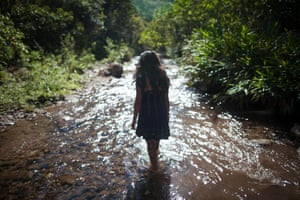 Yanina Avila, 18, the daugher of José de los Santos Sevilla, walks along a river
