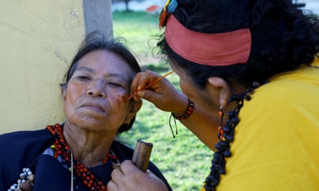 An Asháninka friend uses achiote, a local berry, to paint Luzmila Chiricente’s face, before the performance of Buenas Noticias.