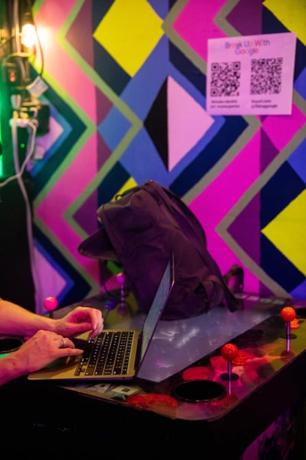 A person types on their computer at a bar