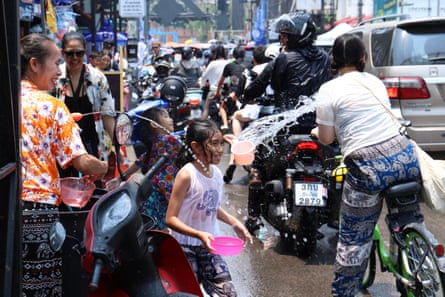 People throw water at one another from the street and on bikes as part of the celebrations of the Songkran festival in Chiang Mai.
