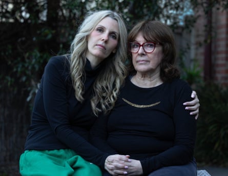 Laura embraces her mother Gail, both seated closely together outdoors