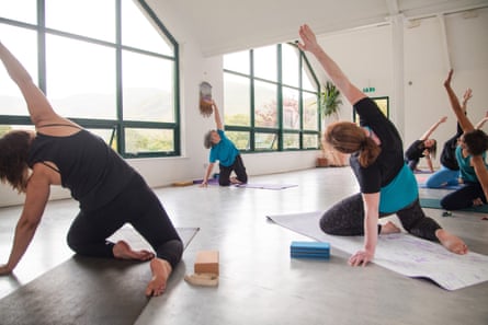 three women doing yoga in a light-filled room