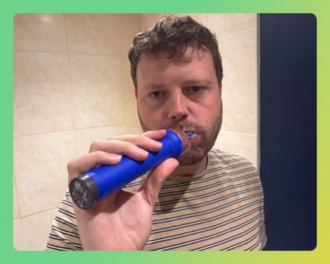 Writer Alan Martin using the Dyson CameraJet toothbrush in a bathroom.