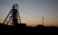 A silhouetted pithead at an Anglo American Platinum open pit mine in South Africa