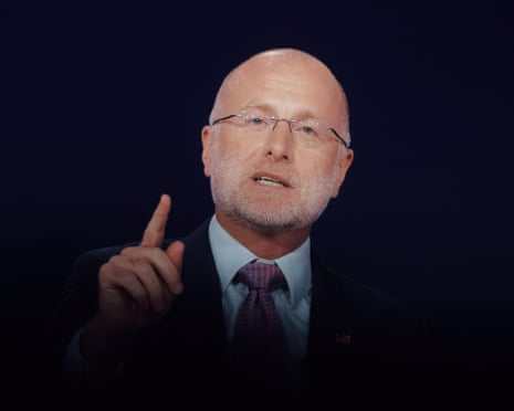 a man in suit with holding his finger up while speaking