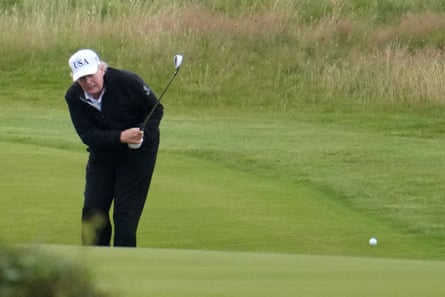 Donald Trump plays a shot on a golf course