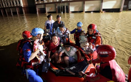 Rescue workers evacuate residents in a rubber dinghy after flood waters inundate villages in Hengzhou.