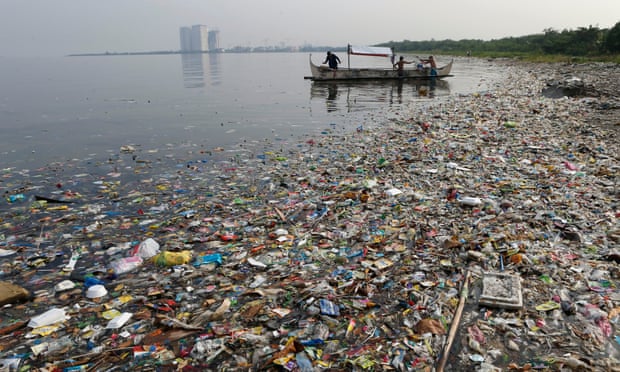 Fishermen float onboard a boat amid mostly plastic rubbish in Manila Bay, the Philippines. Humans have introduced 300m metric tonnes of plastic to the environment every year. 