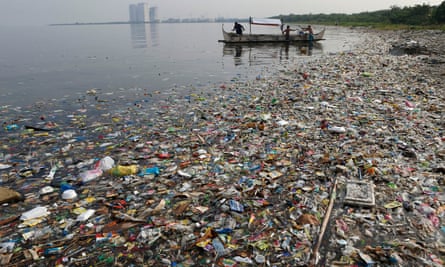 fishing boat works amid garbage in Manila Bay, the Phillipines