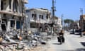 A motorbike drives past buildings destroyed during previous Israeli military fire on the southern Lebanese village of Aita al-Shaab, near the border with northern Israel. 