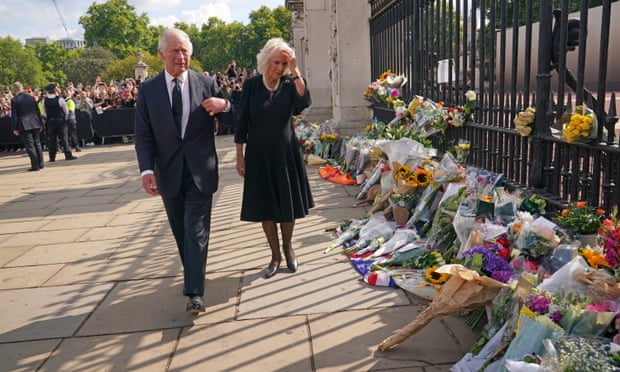 Le roi Charles III et Camilla, la reine surplombant le sanctuaire laissé à l'extérieur du palais de Buckingham.