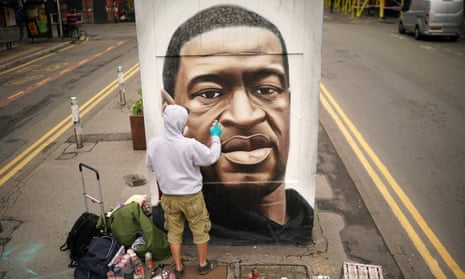 A graffiti artist paints a mural of George Floyd in Manchester last year