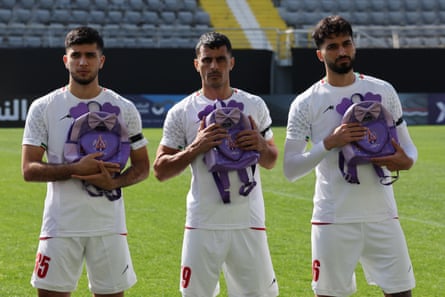 Iran’s Aria Yousefi, Ali Nemati and Mohammad Ghorbani hold school bags in memory of the victims of the school bombing in Minab