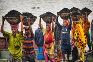 دكا ، بنجلاديش عمال باليومية يحملون سلال من الفحم من سفينة شحن في غابتولي.  إنهم يكسبون حوالي دولار واحد لكل 30 سلة من الفحم يتم تفريغها من السفينة