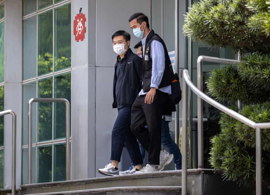 Editor-in-chief Ryan Law is escorted by police as he leaves the office of Next Media, 17 June.
