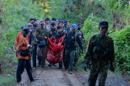 People’s Liberation Army members carry an injured person near Sagaing region in Myanmar.