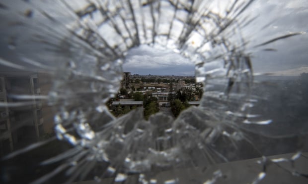 The city of Mekele is seen through a bullet hole in a stairway window of the Ayder specialist referral hospital in the Tigray region of northern Ethiopia on 6 May 2021.