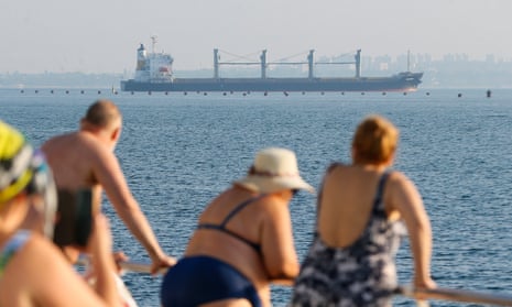 People watch cargo vessel Navi Star carrying 33,000 tonnes of corn to Ireland leave the port of Odesa.