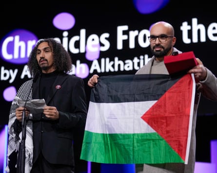 Abdallah al-Khatib and Taqiyeddine Issaad, the latter holding a Palestinian flag during an awards ceremony