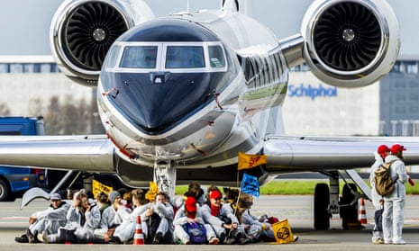 Protesters sit in front of an aircraft at Schiphol airport in the Netherlands