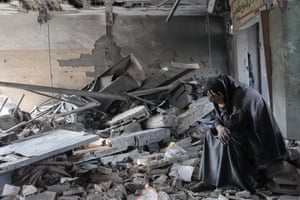 A woman stands amid the rubble of a school