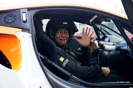Badenoch waves sat in sports car with crash helmet