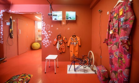 An orange room with various objects including space suits.
