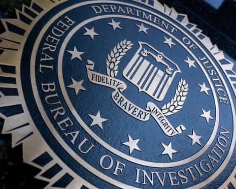 A close-up of the FBI seal, reading 'Department of Justice Federal Bureau of Investigation'.