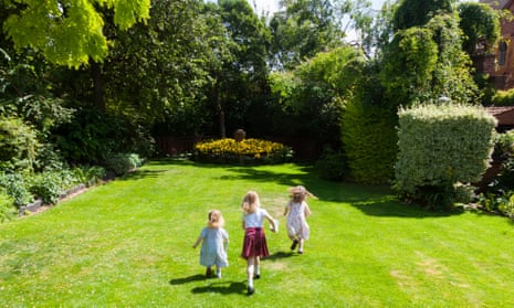 Three children playing in a garden.
