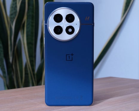 OnePlus 13 showing the blue microfibre back and camera cluster standing up on a table