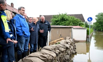 People huddle together behind sandbags which are holding back flood water