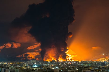 Smoke and flames rise at the site of airstrikes on an oil depot in Tehran