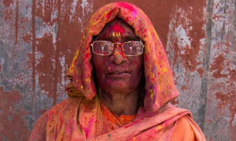 A woman in an orange sari after being covered with coloured dyes