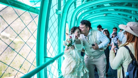 Newlyweds pose for photos on the Huajiang Grand Canyon Bridge
