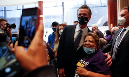 Newsom with arm around woman as they smile for photo