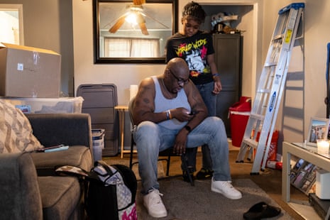 A man on his phone ordering food, his daughter looking at the order