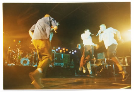 The Beastie Boys on stage, with two members leaping into the air as they perform