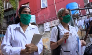 Dr Liz Caballero, left, and student Susana Díaz leave El Vedado polyclinic in Havana, to go door by door looking for possible coronavirus cases.