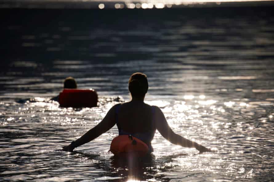 Two of the women silhouetted against the water