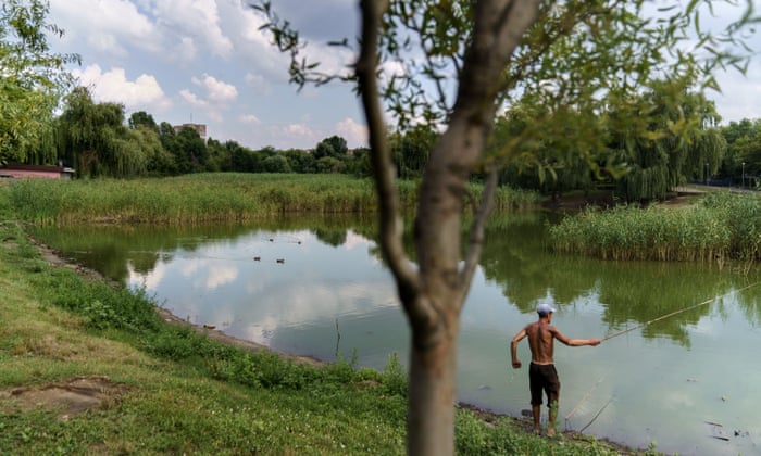 A man fishes in a pond in Kramatorsk, Donetsk region, eastern Ukraine, Wednesday, Aug. 3, 2022. (AP Photo/David Goldman)