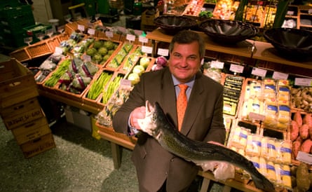 He smiles holding a whole fish