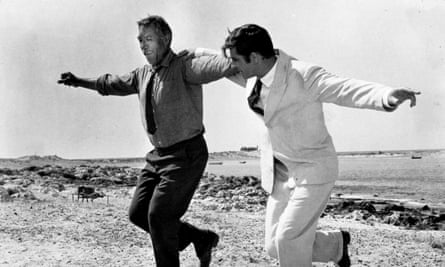 Film still of two men in suits with their arms round each others shoulders dancing