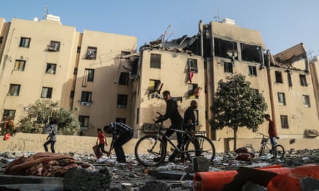 People in Gaza inspect the rubble of a building damaged during Israeli airstrikes
