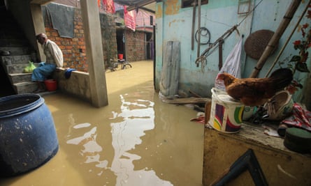 A man in a flooded residential area of Sylhet