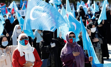 Uighur women wave East Turkestan flags during a protest against China in Istanbul in October