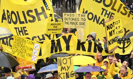 Protesters holding yellow ‘not my king’ banners and placards