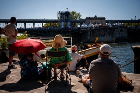 Spectators watch an athlete compete in the men’s 20m high diving event on the Seine