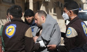A Syrian man is escorted by civil defence workers in Khan Sheikhun.